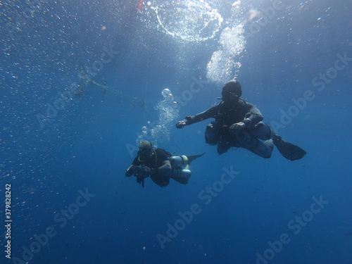 Buceadores de buceo técnico realizando ejercicios bajo el mar