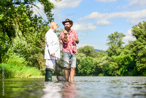 Fishing is not boring for me. friends men with fishing rod and net. happy fishermen. Good profit. hobby of businessman. retirement fishery. Fly fishing adventures. retired dad and mature bearded son