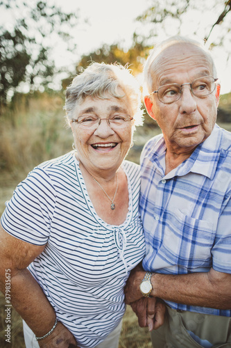 Cute elderly couple smiling together outside