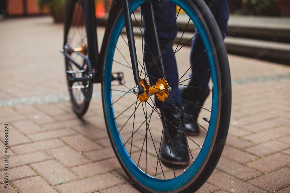 Man with black boots walks his bike. Man with black boots walks his bike.