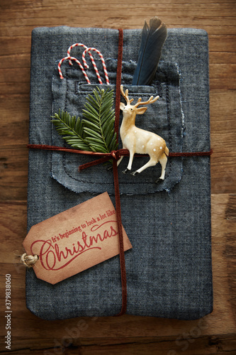 Hipster gift wrapped in denim with leather twine and ornaments photo