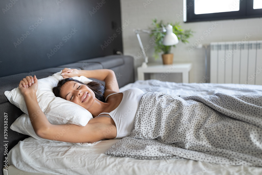 Young beautiful woman sleeping and smiles in her sleep in bed Young beautiful woman sleeping and smiles in her sleep in bed