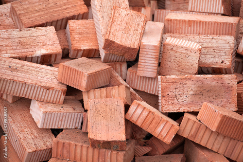 Red bricks piled in a heap. Background. Construction concept, building materials.