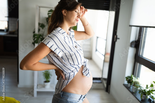 Tired pregnant woman expecting baby and feeling exhausted at home on maternity leave