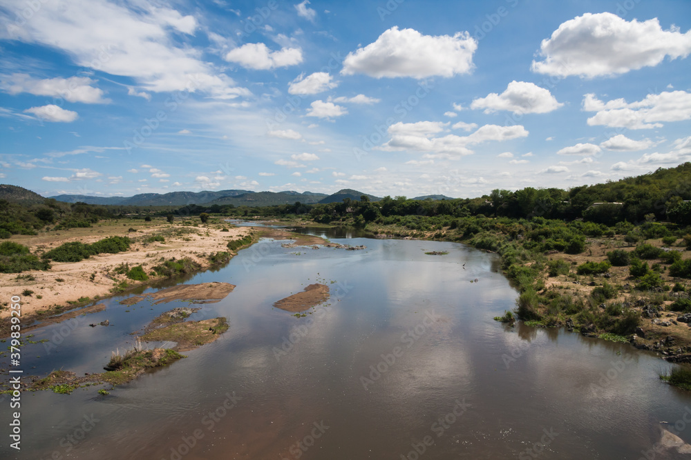 Scenic view from Malelane bridge at the entrance to Kruger National Park of the Crocodile river with cloud reflections