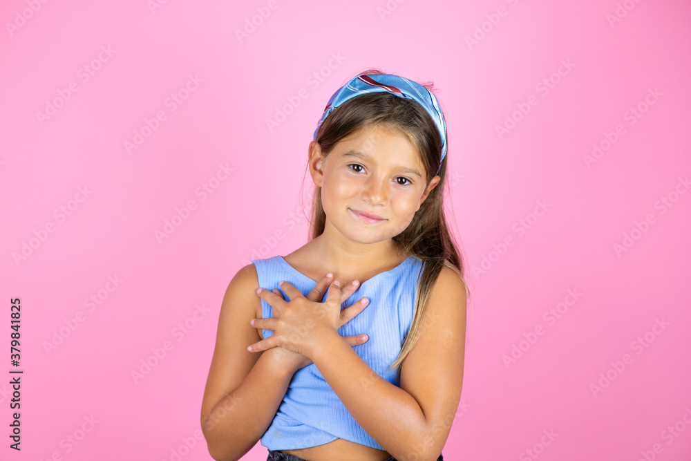 Young beautiful child girl over isolated pink background smiling with her hands on her chest and grateful gesture on her face. Young beautiful child girl over isolated pink background smiling with her hands on her chest and grateful gesture on her face.