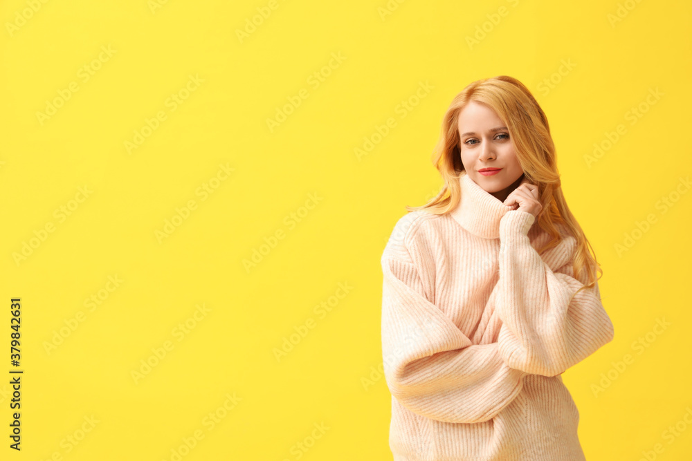 Beautiful young woman wearing warm pink sweater on yellow background. Space for text Beautiful young woman wearing warm pink sweater on yellow background. Space for text