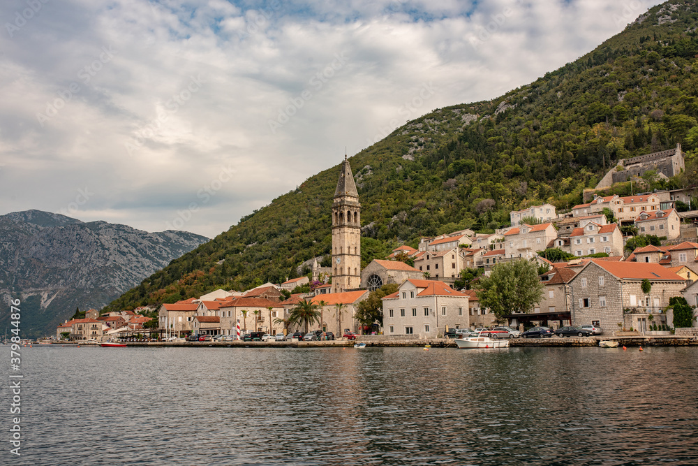 Perast historic town at Kotor bay. Ancient city in Montenegro. Beautiful bay with old buildings, cafes, restaurants and parked tourist cars.