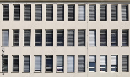 White facade of modern office building with long vertical PVC windows. Background and texture 