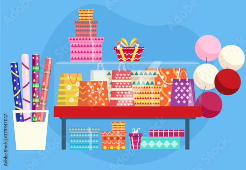 Showcase with gift bags, present boxes, rolls of wrapping paper and baloons.
