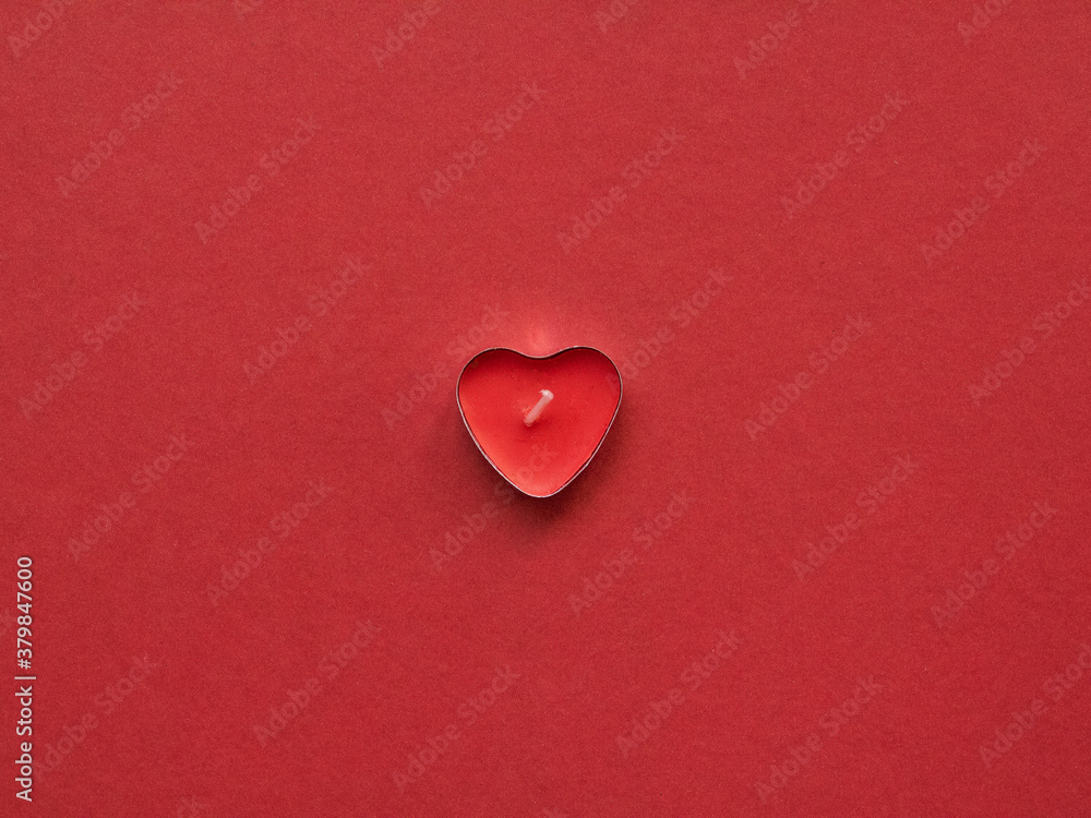 Hearth shaped candle on red background. love background