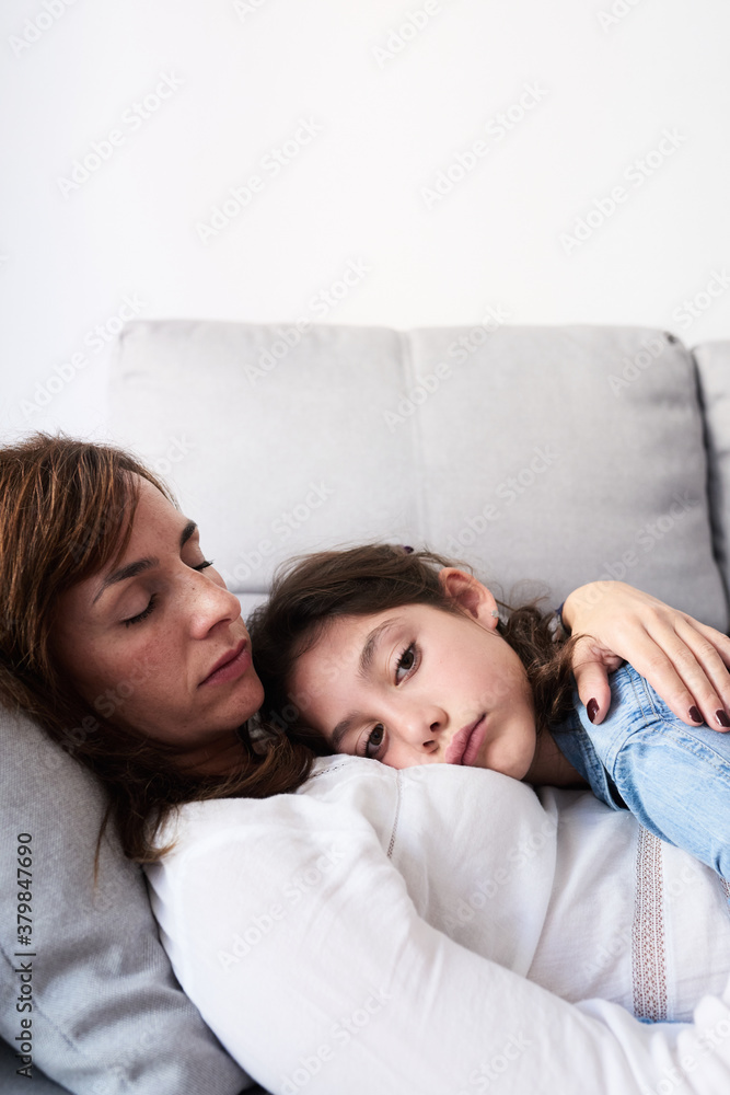 Sleeping mother embracing her adorable daughter on couch. Sleeping mother embracing her adorable daughter on couch.