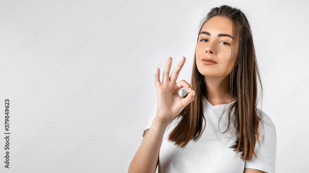 Pretty Young woman laughing and showing OK gesture. Studio shot white background. Human emotions concept. Copy space Pretty Young woman laughing and showing OK gesture. Studio shot white background. Human emotions concept. Copy space