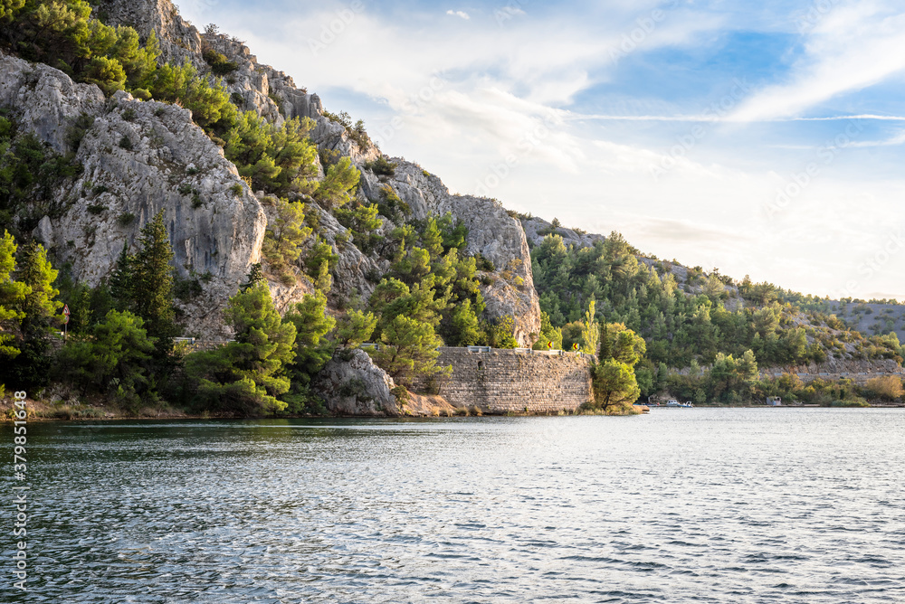 View of the steep mountain near the river Krka and the road along the mountain near the town of Skradin, Croatia View of the steep mountain near the river Krka and the road along the mountain near the town of Skradin, Croatia
