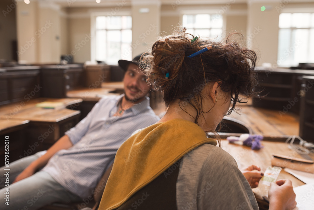 Students talking while sitting at desks in the library Students talking while sitting at desks in the library