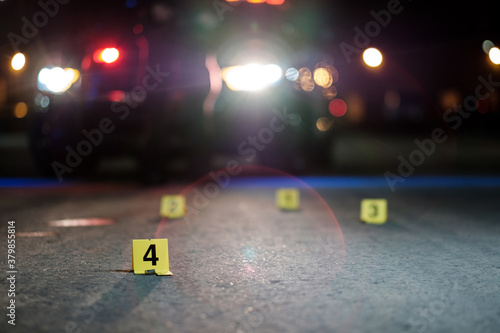 Shell casings are marked with evidence tags at a crime scene
