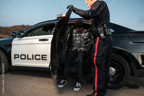 A suspect seated in the back of a police cruiser