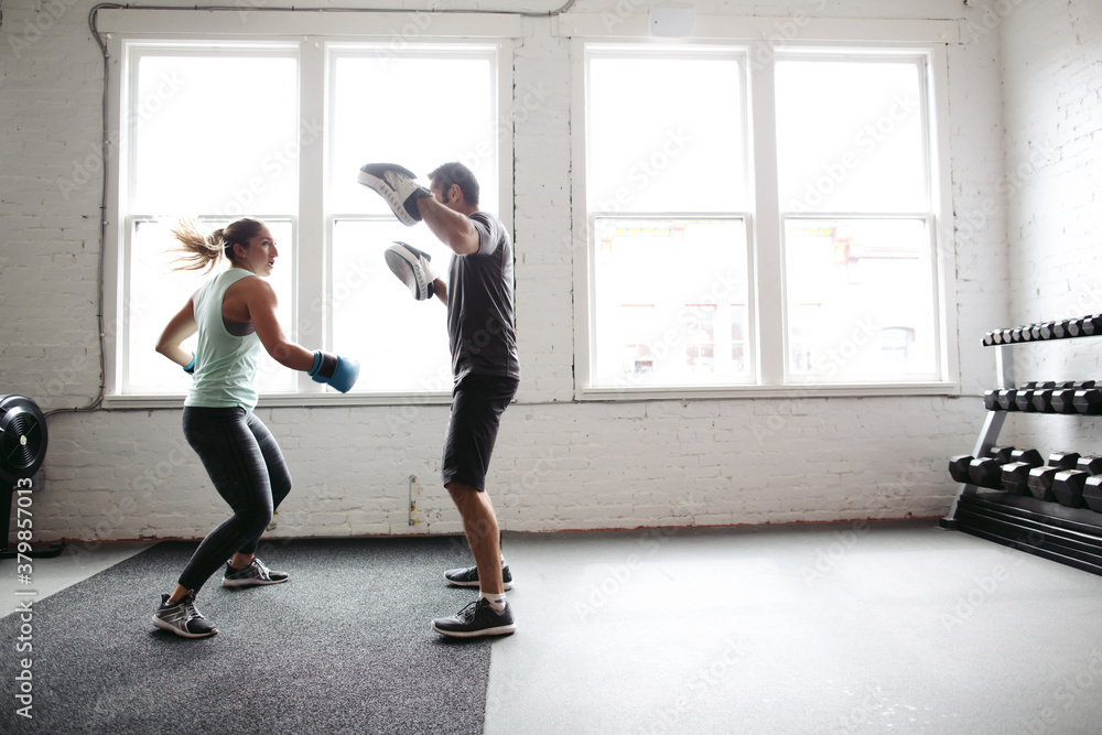 Strong, healthy woman working out in gym - boxing with trainer Strong, healthy woman working out in gym - boxing with trainer