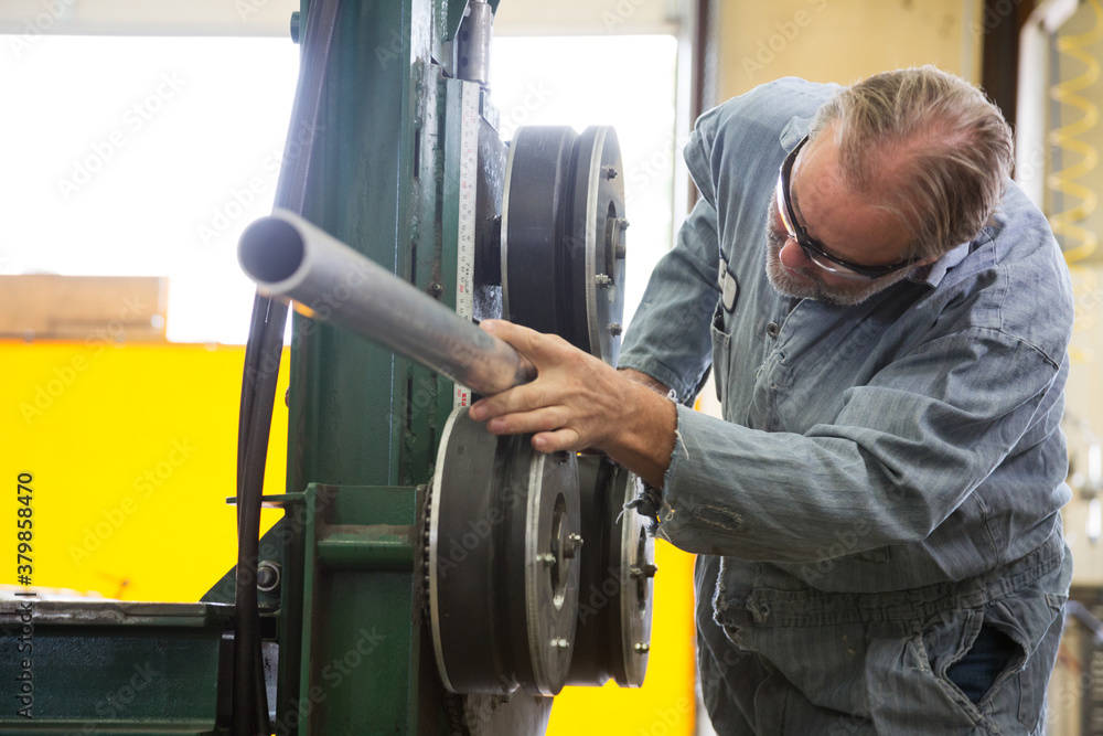 Factory worker bending pipe Factory worker bending pipe