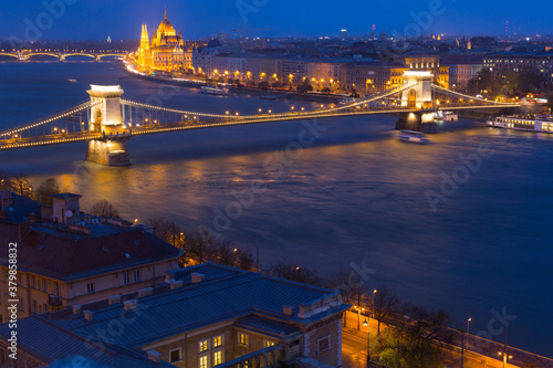 Chain Bridge and Parliament in night light of Budapest outdoors.