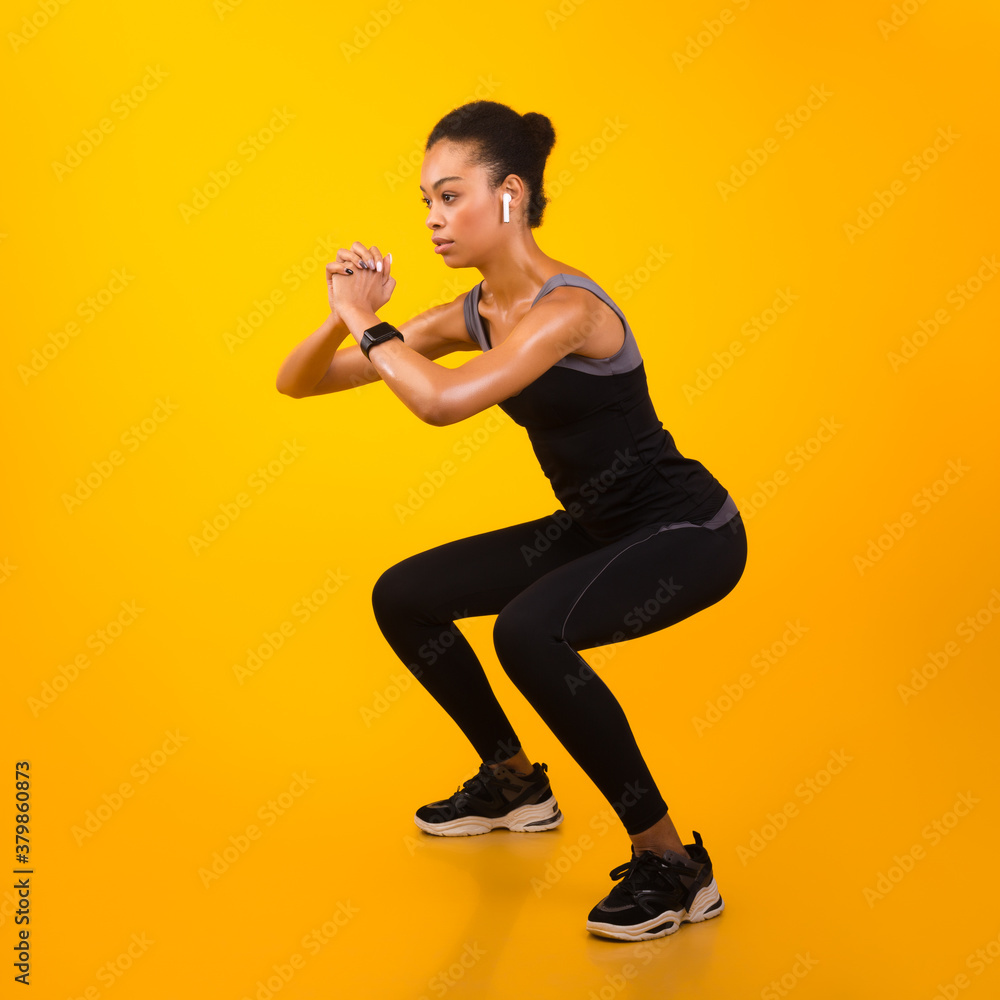 Afro Lady Exercising Doing Deep Squat Working Out, Studio Shot Afro Lady Exercising Doing Deep Squat Working Out, Studio Shot