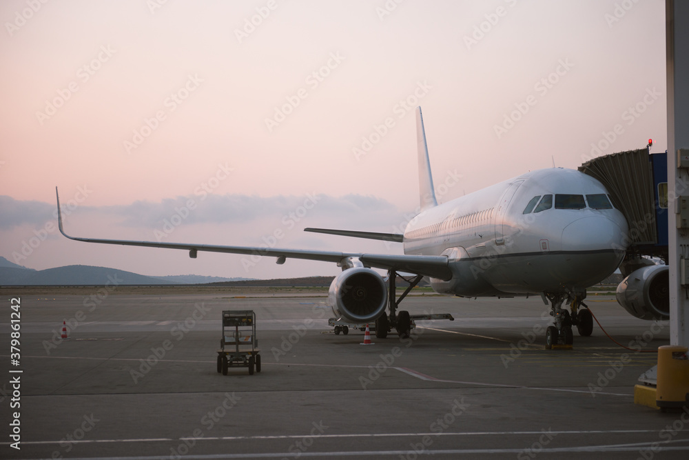 White airliner on the airdrome preparing for departure during su White airliner on the airdrome preparing for departure during su