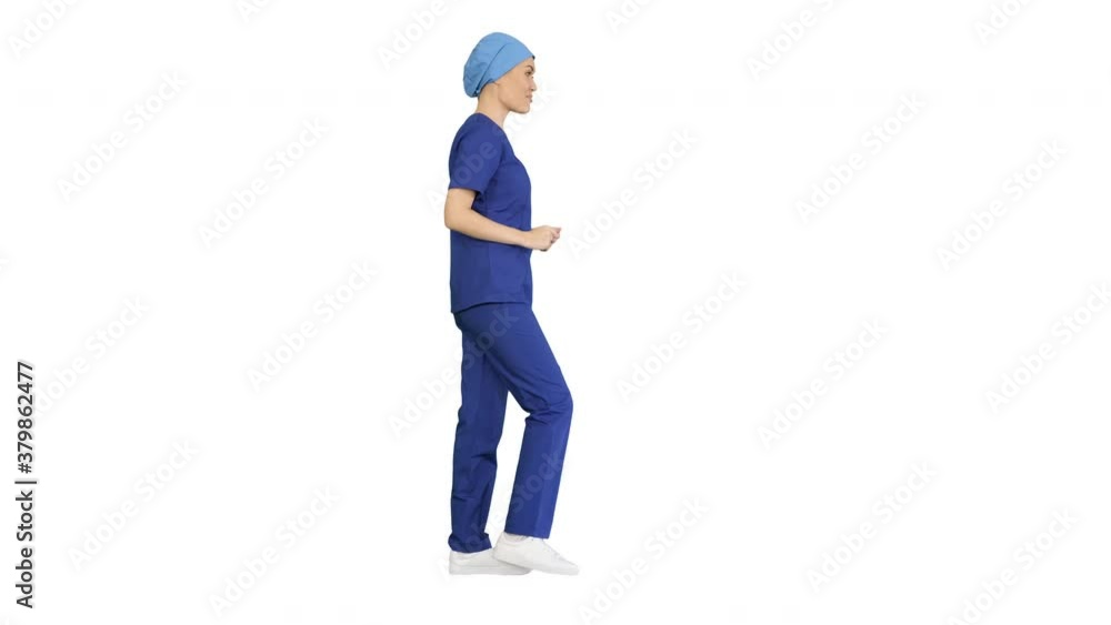 Smiling female in blue medical uniform advertising clinic services while walking on white background. Smiling female in blue medical uniform advertising clinic services while walking on white background.