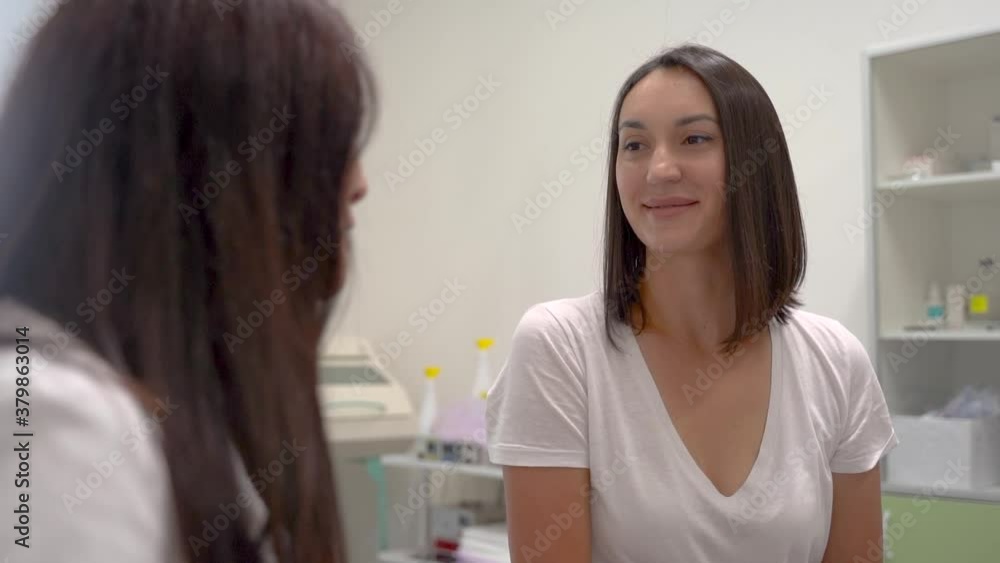Female patient smiling and talking with doctor about prescription and treatment in the office. Medium shot. Female patient smiling and talking with doctor about prescription and treatment in the office. Medium shot.