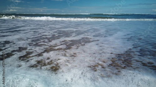 Waves breaking on the beach beneath viewer in 4k 60fps