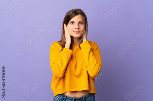 Young Slovak woman isolated on purple background frustrated and covering ears © luismolinero