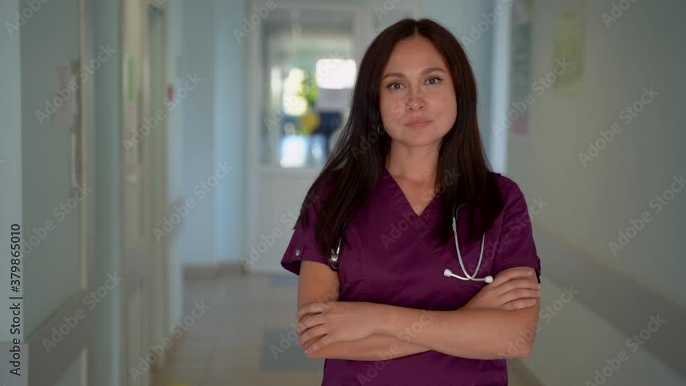 Serious nurse with arms crossed in a hospital corridor. Copy space. Medium shot. Serious nurse with arms crossed in a hospital corridor. Copy space. Medium shot.