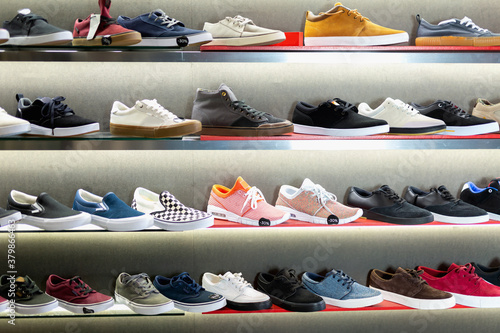 A lot of modern fashionable stylish casual men shoes on shelves in shoe store