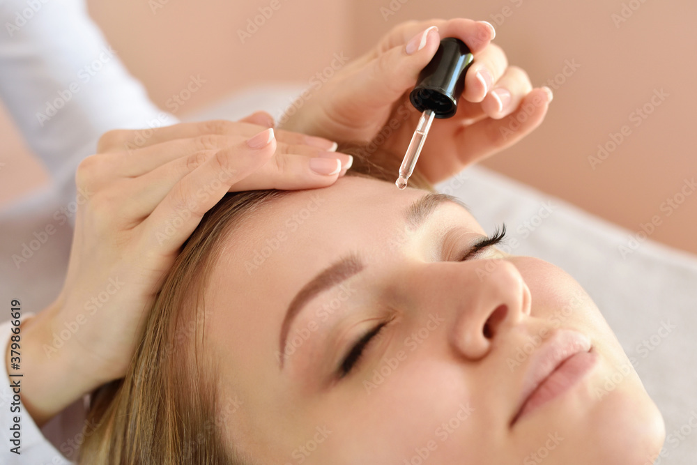 Closeup of beautiful woman receiving serum for skin moisturizing from pipette. Beauty, skincare cosmetology. Closeup of beautiful woman receiving serum for skin moisturizing from pipette. Beauty, skincare cosmetology.