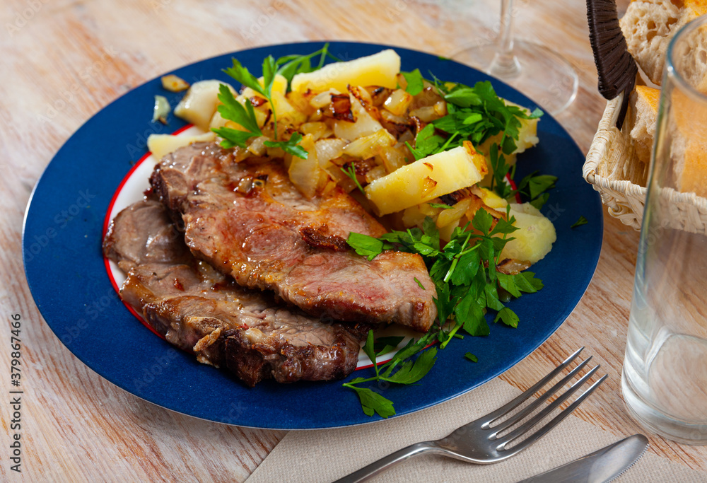 Roasted pork chop with vegetable garnish of boiled potatoes