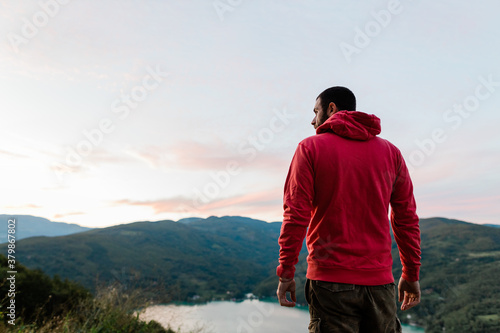 Young man enjoying the view of the lake in sunset photo