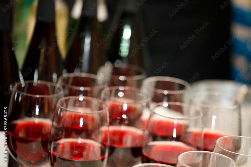 Viele Flaschen und Gläser mit Rotwein auf Bankett, Catering oder Event.