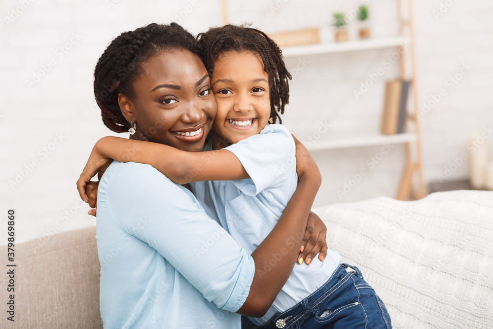 Obraz premium Black mother and daughter hugging at home