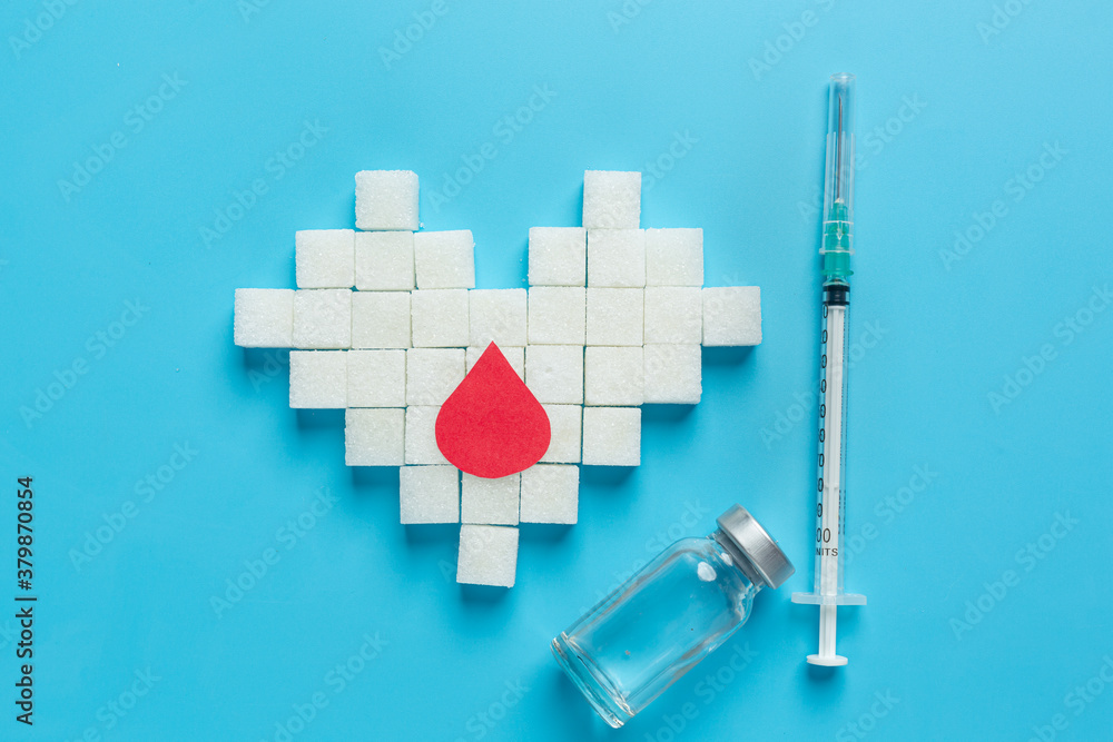 World diabetes day; sugar cubes are arranged in the shape of heart and hypodermic syringeon World diabetes day; sugar cubes are arranged in the shape of heart and hypodermic syringeon