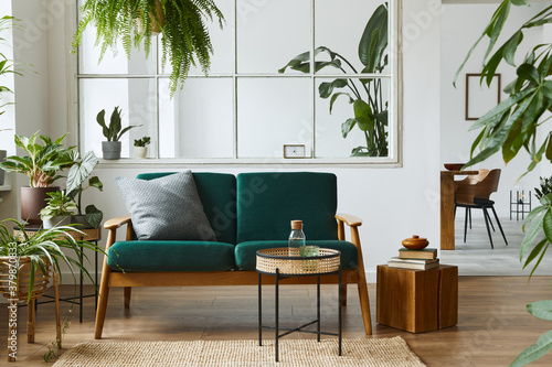 Stylish scandinavian living room interior with green velvet sofa  coffee table  carpet  plants  furniture  elegant accessories in modern home decor. Template.