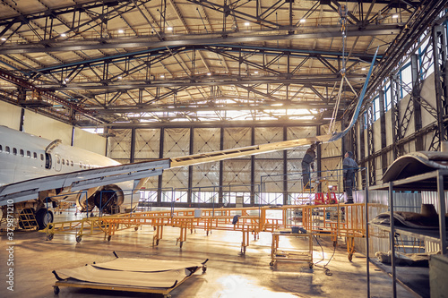 Wing and fuselage of the airplane in the aviation hangar