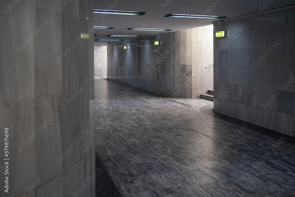 Underground passage for pedestrians with marble flooring and tiles.