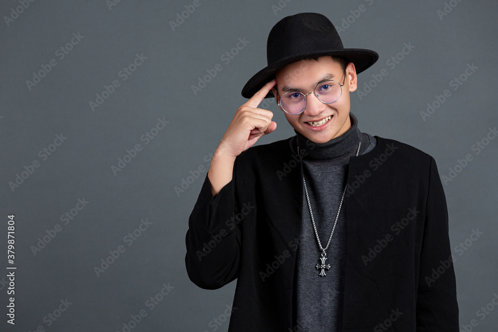 portrait of male model pointing finger and smiling on dark background portrait of male model pointing finger and smiling on dark background