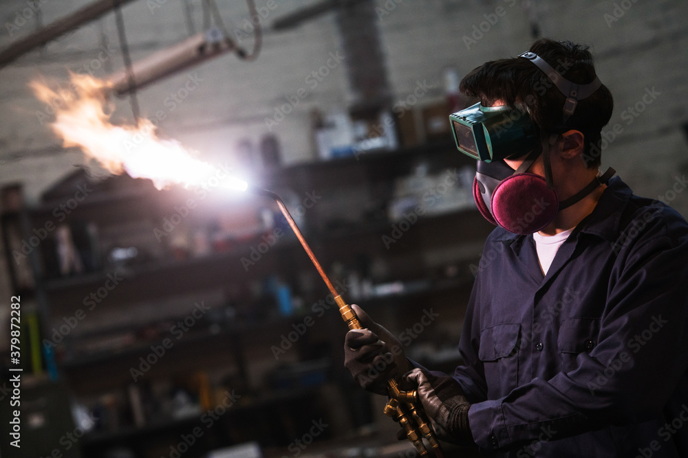 Welder adjusts his torch viewed from side Welder adjusts his torch viewed from side