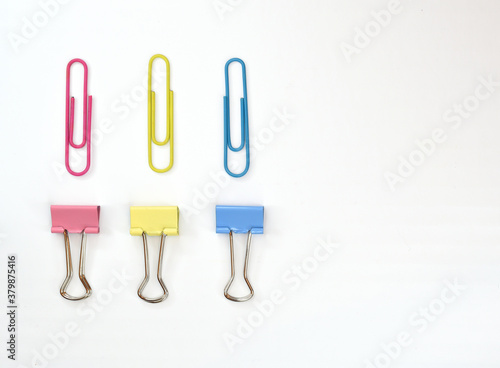 Colored stationery and paper clips, arranged in two rows opposite each other