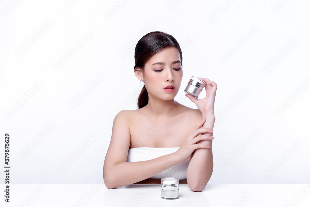 Portrait of beautiful charming young Asian woman posing facial with cosmetic and sitting with white table, beauty of female face with skincare on white background, healthcare and skin care concept. Portrait of beautiful charming young Asian woman posing facial with cosmetic and sitting with white table, beauty of female face with skincare on white background, healthcare and skin care concept.