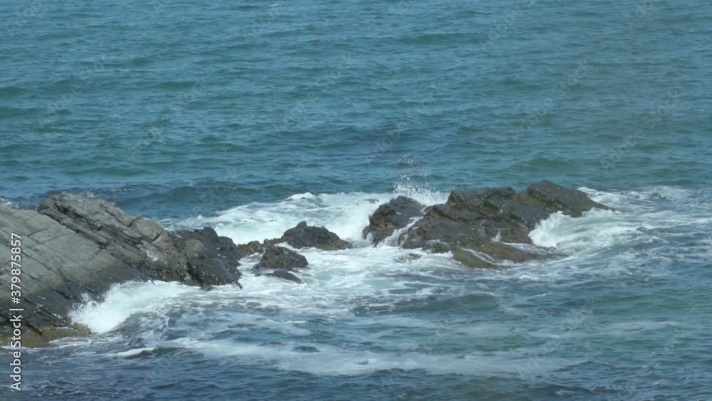 Drone shot of sea waves movements towards rocky coastline and view of water power and purity Drone shot of sea waves movements towards rocky coastline and view of water power and purity