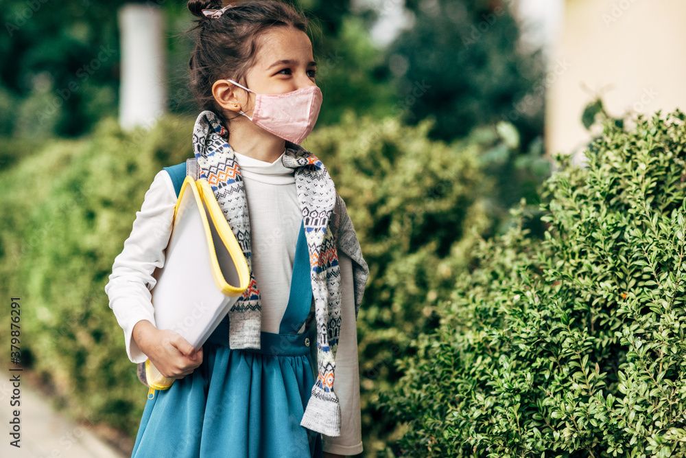 Horizontal image of a kid wearing protective face mask going back to