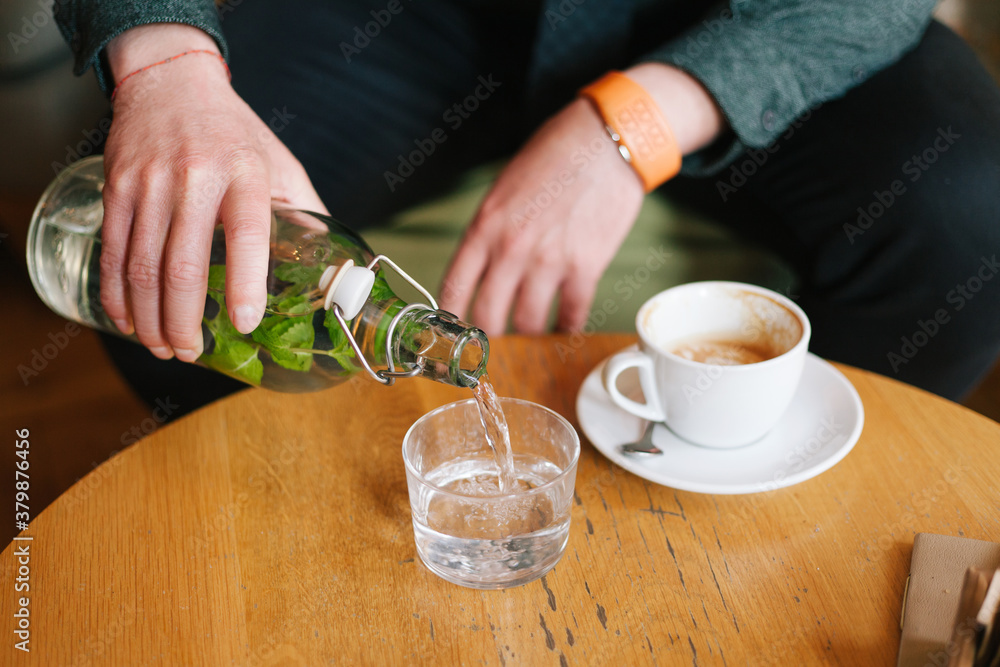 Male person pouring water in the glass Male person pouring water in the glass
