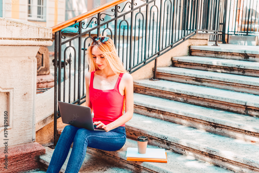 Young woman using laptop while sitting on the stairs outdoor Young woman using laptop while sitting on the stairs outdoor