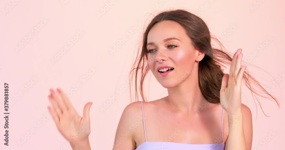 Young happy woman dancing over pink background at studio. Cheerful caucasian model dancing at studio. Happy young adult girl. Young happy woman dancing over pink background at studio. Cheerful caucasian model dancing at studio. Happy young adult girl.